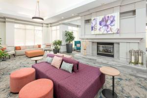 salon z fioletową kanapą i kominkiem w obiekcie Hilton Garden Inn Lafayette/Cajundome w mieście Lafayette