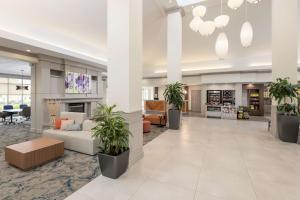 un hall de bureau avec un canapé et des plantes en pot dans l'établissement Hilton Garden Inn Lafayette/Cajundome, à Lafayette