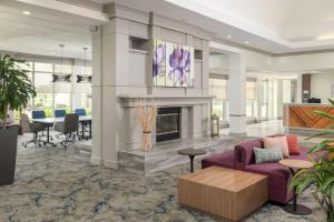 salon z kominkiem i fioletową kanapą w obiekcie Hilton Garden Inn Lafayette/Cajundome w mieście Lafayette