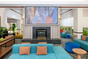 a living room with a blue couch and a fireplace at Hilton Garden Inn Ft. Lauderdale SW/Miramar in Miramar