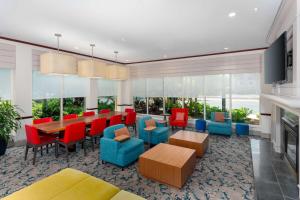 une salle à manger avec des chaises rouges, une table et des chaises dans l'établissement Hilton Garden Inn Ft. Lauderdale SW/Miramar, à Miramar