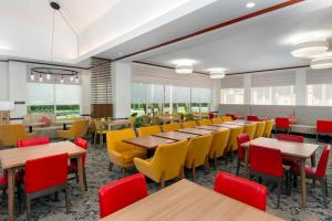 a dining room with tables and yellow chairs at Hilton Garden Inn Ft. Lauderdale SW/Miramar in Miramar