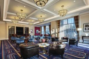 a hotel lobby with couches tables and chairs at Higgins Hotel, Official Hotel of The National WWII Museum, Curio Collection by Hilton in New Orleans