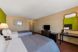 una camera d'albergo con due letti e uno specchio di Quality Inn Airport a Woodson Terrace