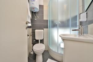 a bathroom with a toilet and a sink and a shower at Apartments Donat in Zadar