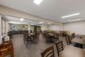 a dining room with tables and chairs and a kitchen at Quality Inn Airport in Woodson Terrace