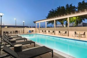 a swimming pool with lounge chairs and tables at Hampton Inn Stockton, Ca in Stockton