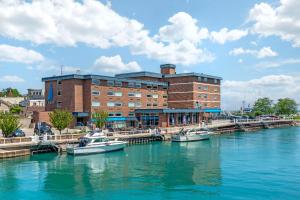 a building with boats docked in the water in front at The Harborview, Ascend Hotel Collection in Port Washington