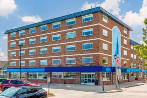 a large red brick building with an american flag at The Harborview, Ascend Hotel Collection in Port Washington