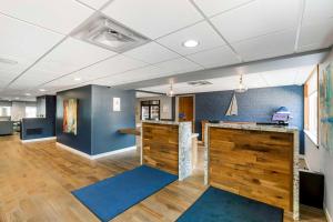 an office with a reception desk and blue walls at The Harborview, Ascend Hotel Collection in Port Washington