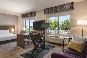 a hotel room with a bed and a desk with a computer at Hampton Inn Stockton, Ca in Stockton