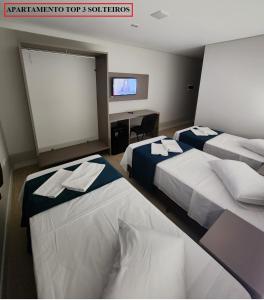 Habitación de hotel con 2 camas y TV de pantalla plana. en HOTEL CAMPO GRANDE en Campo Grande