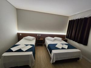 大坎普的住宿－HOTEL CAMPO GRANDE，一间设有两张床铺和毛巾的房间