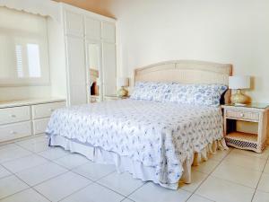 um quarto com uma cama com uma colcha azul e branca em Beautiful Seaside 2BR Apartments em Christ Church
