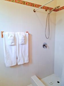 a bathroom with white towels hanging on a shower at Beautiful Seaside 2BR Apartments in Christ Church