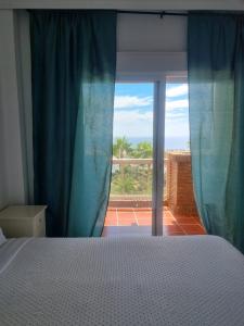 een slaapkamer met een bed en een raam met uitzicht bij Sunny Coast in Sitio de Calahonda