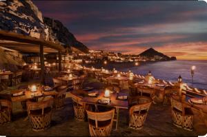 a restaurant with tables and chairs on the beach at night at Best Location in Medano Beach -Marina Sol LRG 2 Bed Steps to Beach, Downtown & Marina in Cabo San Lucas