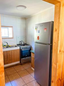 a kitchen with a stainless steel refrigerator and a stove at Casa En El Tabo Magnolia in El Tabo