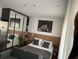 ein Hotelzimmer mit einem Bett und einem Spiegel in der Unterkunft Studio Aconchegante in São Paulo