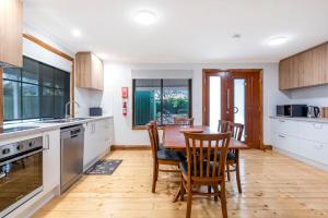 a kitchen with a wooden table and chairs at Welcoming Ambiant 3BR Abode in Tanunda