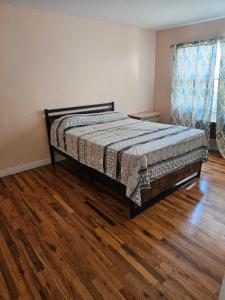 a bedroom with a bed and a wooden floor at 1st floor Private Apt near Ferry to NYC and Park in Tompkinsville