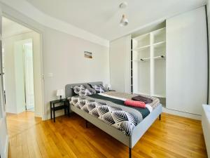Un dormitorio con una cama con almohadas. en Cozy Appart'3 - Centre ville & Proche Gare - Cozy Houses, en Massy