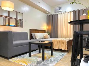 uma sala de estar com um sofá e uma mesa em Bea’s Transient (Condo Studio Room for 2!) em Manila