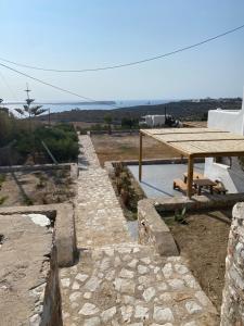 un camino de piedra con una mesa de picnic y el océano en Nerea Sunset View Apartment, en Agia Irini Paros