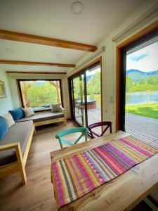 a room with a bed and two chairs and a large window at Huella Patagonia Lodge in Puerto Dunn