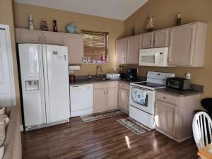 uma cozinha com electrodomésticos brancos e pisos em madeira em Guest house withl kitchen living room 65" tv solar heated pool em Palm Coast