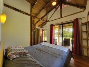 a bedroom with a bed in a room with a window at Corcovado Guest House in Drake