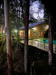 a house in the woods at night with lights at Recanto dos Sonhos Guest House in Lumiar