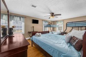 a bedroom with a bed and a ceiling fan at Dazzling Centrally Located Ocean View w Huge Private Yard, 2 Decks, Firepit, BBQ in Myrtle Beach