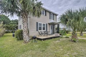 a house with a picnic table and a palm tree at Dazzling Centrally Located Ocean View w Huge Private Yard, 2 Decks, Firepit, BBQ in Myrtle Beach