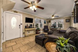 a living room with a couch and a ceiling fan at Dazzling Centrally Located Ocean View w Huge Private Yard, 2 Decks, Firepit, BBQ in Myrtle Beach