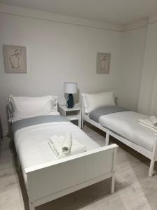 - 2 lits dans une chambre aux murs blancs dans l'établissement 2 bedroom with garden- Wembley, à Preston