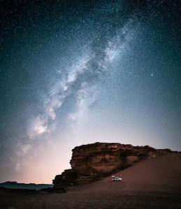 a car parked in the desert under a starry sky at Wadirum Zeid camp in Wadi Rum