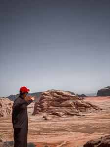 a man standing in the desert flying a kite at Wadirum Zeid camp in Wadi Rum