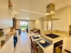 a kitchen and living room with a stove top oven at Flat 113 Eco Resort Praia dos Carneiros in Praia dos Carneiros