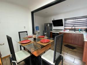 une salle à manger avec une table et des chaises ainsi qu'une cuisine dans l'établissement HOSPEDAJE SUSTENTABLE, à Calle Larga