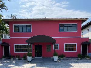 een rood huis met een zwart dak bij Pousada Sol da Enseada Guarujá in Guarujá