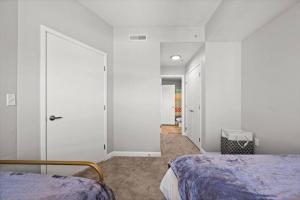 a bedroom with white walls and a bed and a door at Charming Downtown Getaway in Salt Lake City