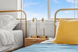 a bed with a yellow pillow next to a window at Central City Escape in Salt Lake City