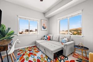 a living room with a couch and two windows at Central City Escape in Salt Lake City