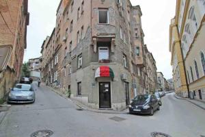 two cars parked in front of a building on a street at Urban Den in Sarajevo