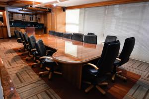 una sala de conferencias con una gran mesa de madera y sillas en Hotel Park Nilo Reforma, en Ciudad de México