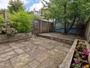 a patio with flowers and a fence at Single room with en-suite shower room in Zone 1 London in London