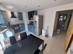 a kitchen with a black table and a refrigerator at Single room with en-suite shower room in Zone 1 London in London
