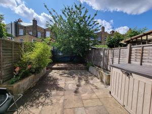 a garden with a fence and a tree at Single room with en-suite shower room in Zone 1 London in London
