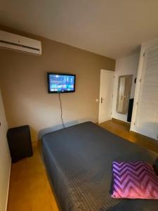 a bedroom with a bed and a tv on the wall at Bungalow con jardín y piscina in San Bartolomé de Tirajana +13 photos
